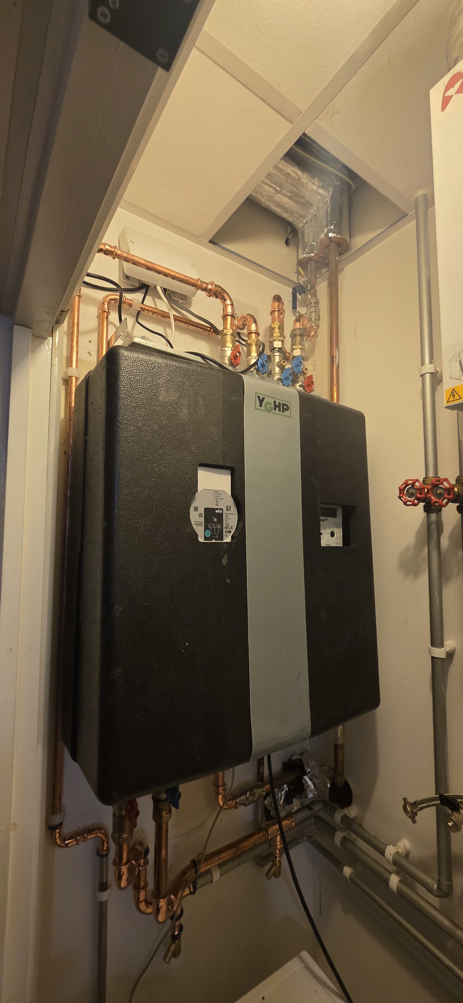 A newly installed hiu for heating and hot water sited in a compact cupboard