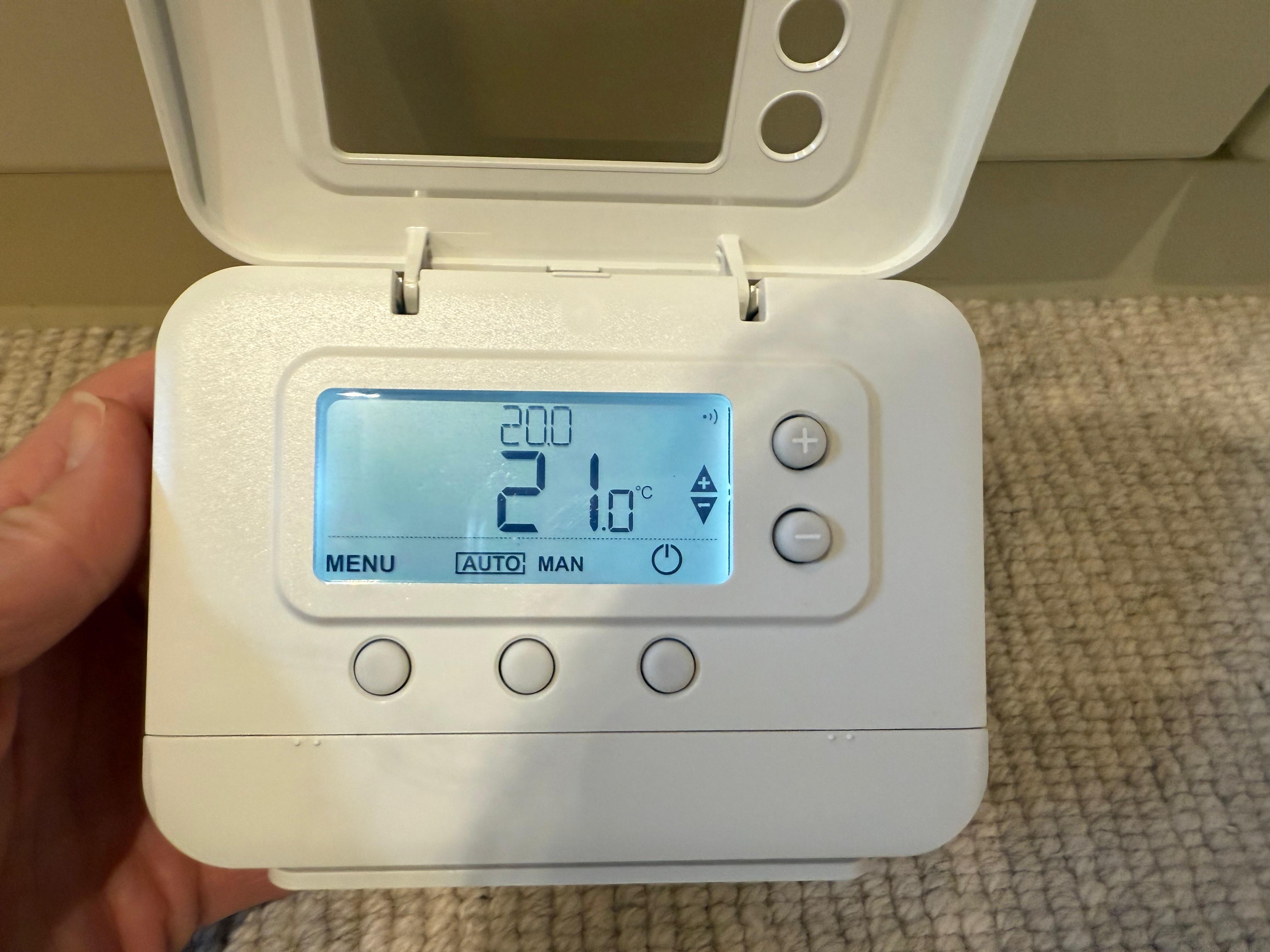 Room thermostat in auto mode set to 21°C for home heating control